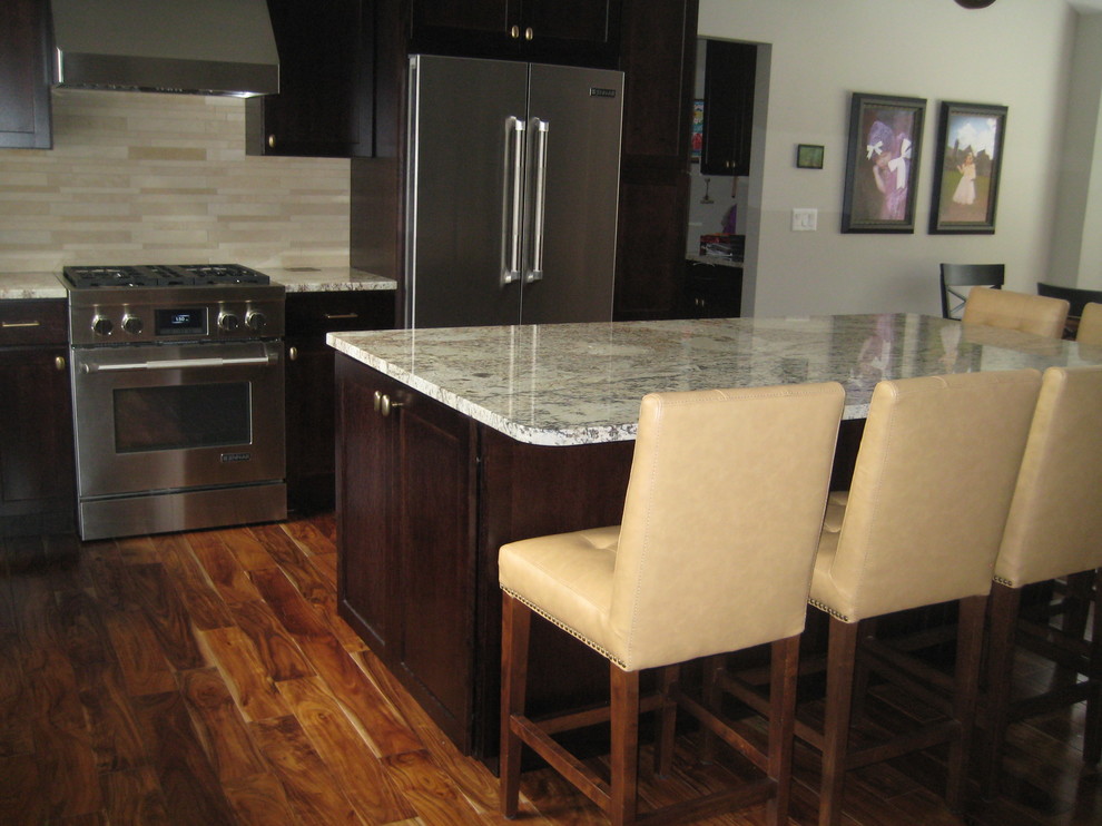 Example of a mid-sized mountain style l-shaped dark wood floor open concept kitchen design in Grand Rapids with a double-bowl sink, recessed-panel cabinets, dark wood cabinets, granite countertops, beige backsplash, matchstick tile backsplash, stainless steel appliances and an island