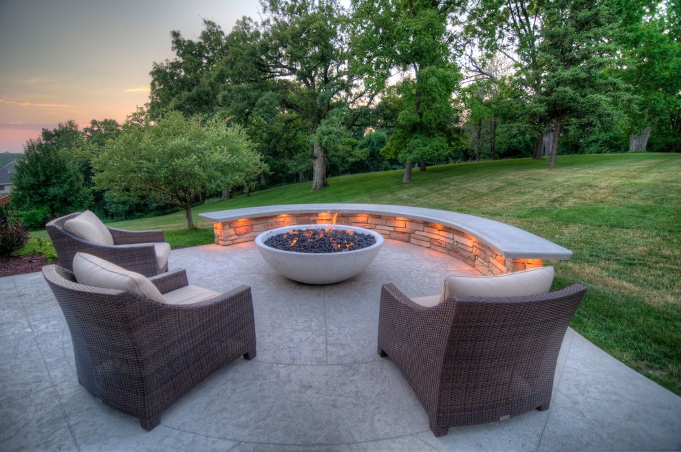 Design ideas for a large transitional backyard patio in Cedar Rapids with a fire feature, stamped concrete and a roof extension.