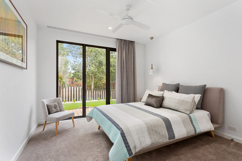 Contemporary bedroom in Melbourne with white walls, carpet and beige floor.