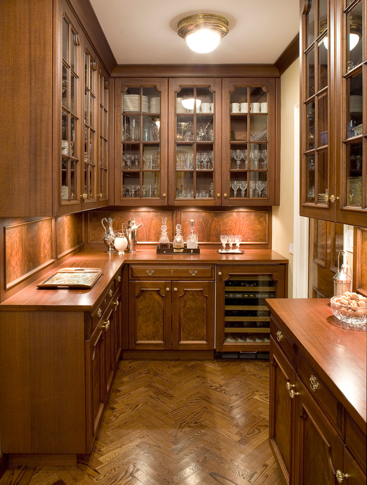 Photo of a mid-sized traditional u-shaped wet bar in Denver with glass-front cabinets, dark wood cabinets, wood benchtops, brown splashback, timber splashback, dark hardwood floors, brown floor and brown benchtop.