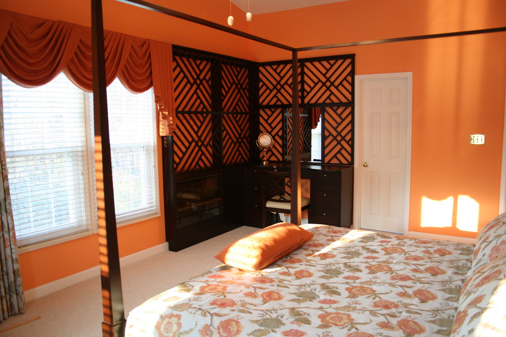 This is an example of a mid-sized eclectic guest bedroom in DC Metro with orange walls, carpet, grey floor, a ribbon fireplace and a wood fireplace surround.
