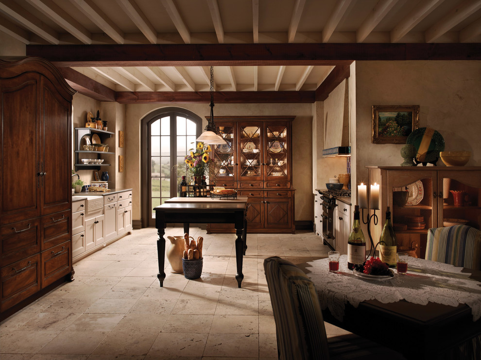Inspiration for a mid-sized rustic galley limestone floor eat-in kitchen remodel in Chicago with a farmhouse sink, shaker cabinets, beige cabinets, stainless steel appliances and an island