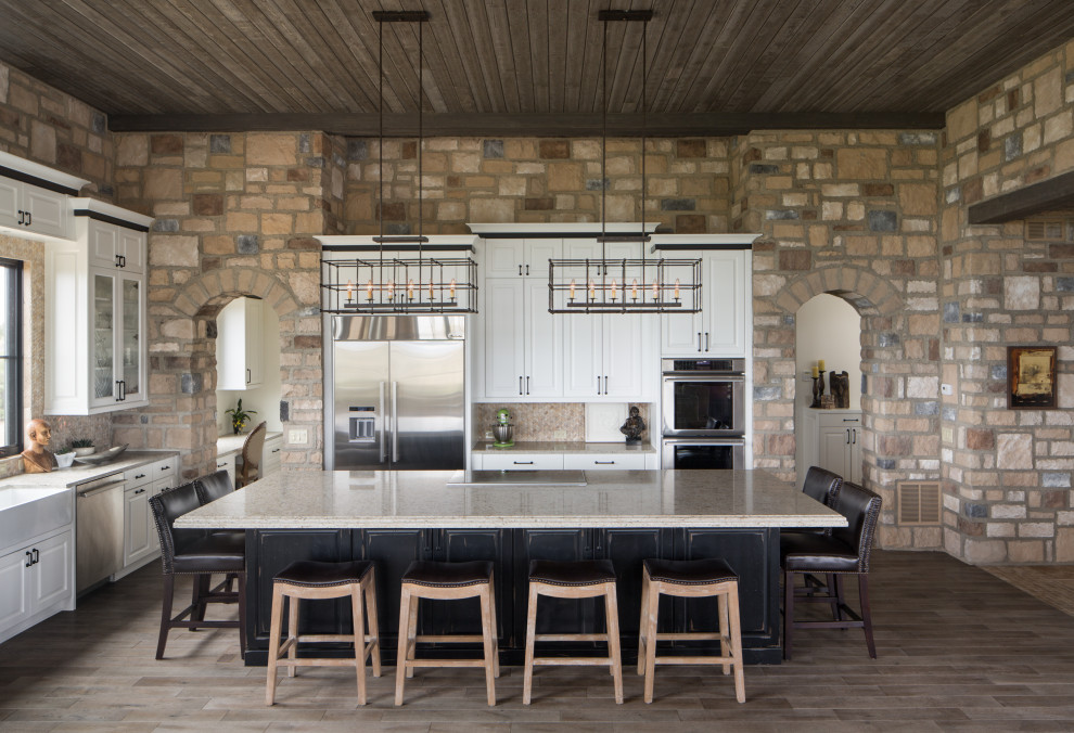 Example of a mountain style kitchen design in Denver with raised-panel cabinets, white cabinets, beige backsplash and stone tile backsplash