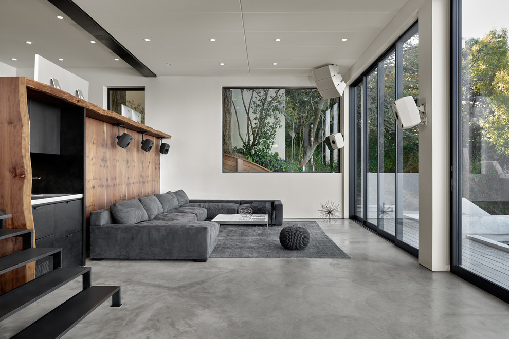 Large modern open concept living room in San Francisco with a home bar, white walls, concrete floors and grey floor.