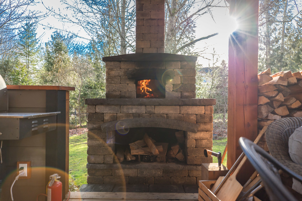 Example of a large mountain style backyard outdoor kitchen deck design in Vancouver with a roof extension