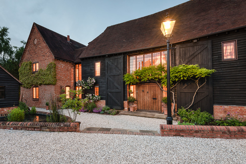 Inspiration for a large country black exterior in Berkshire with mixed siding and a gable roof.