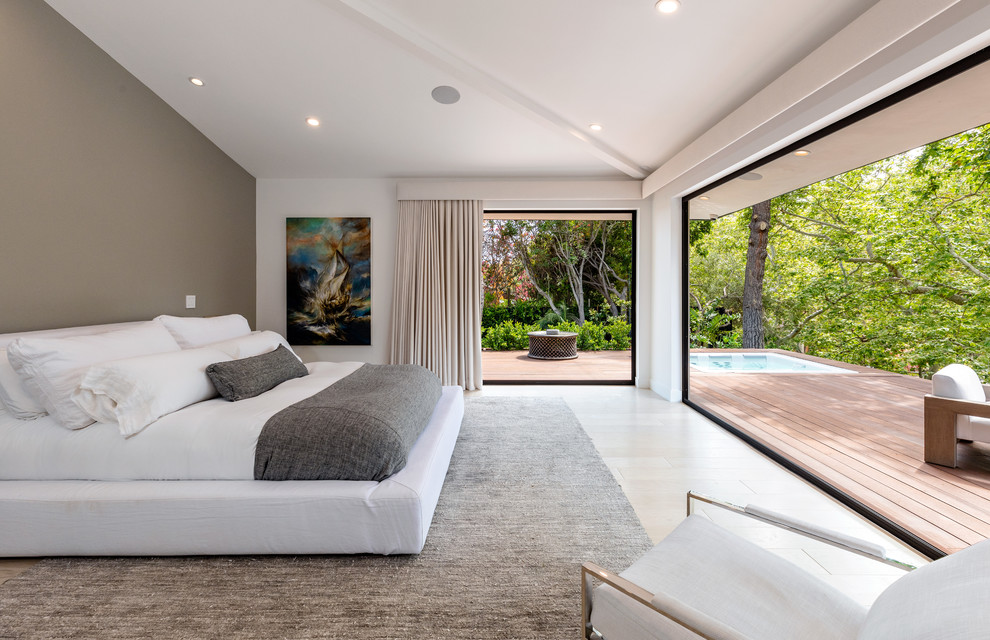 Photo of a contemporary master bedroom in Los Angeles with white walls and beige floor.