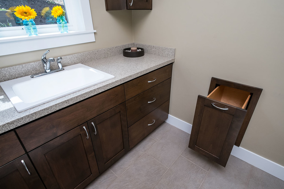 Design ideas for a large modern dedicated laundry room in Portland with a drop-in sink, shaker cabinets, dark wood cabinets, quartz benchtops, beige walls, medium hardwood floors and a side-by-side washer and dryer.