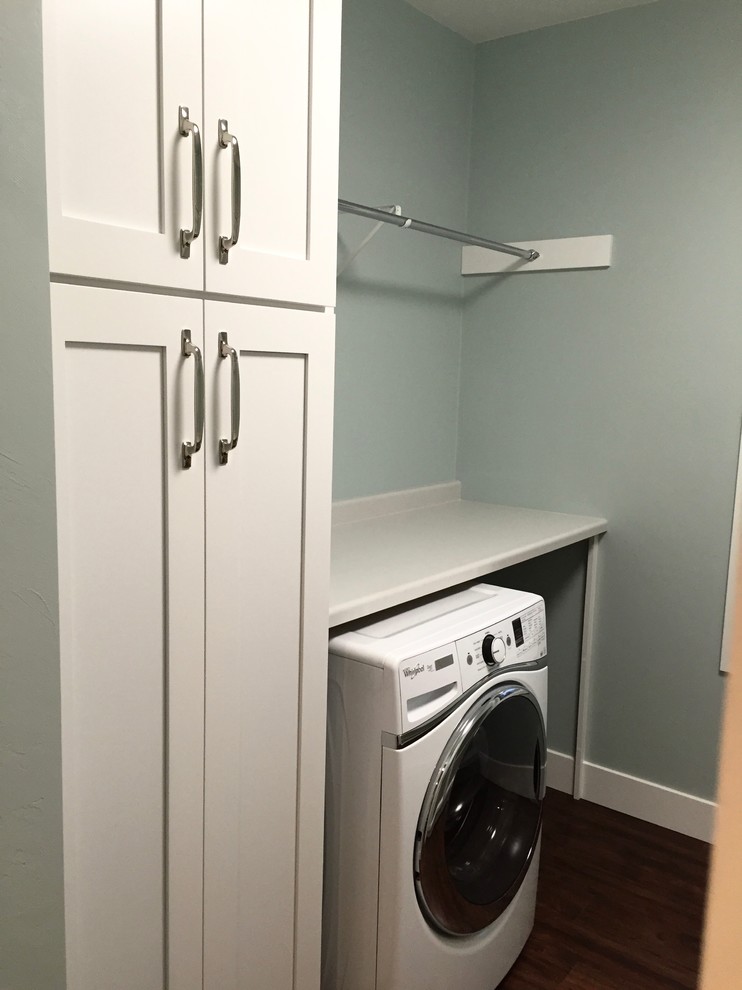 Photo of a mid-sized contemporary u-shaped dedicated laundry room in Other with a drop-in sink, shaker cabinets, white cabinets, laminate benchtops, grey walls, vinyl floors and a side-by-side washer and dryer.