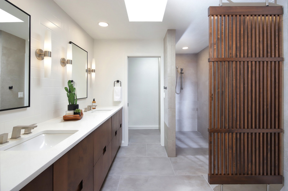 Design ideas for a mid-sized midcentury master bathroom in Phoenix with flat-panel cabinets, medium wood cabinets, a curbless shower, a one-piece toilet, gray tile, porcelain tile, white walls, porcelain floors, an undermount sink, engineered quartz benchtops, grey floor, an open shower, white benchtops, a niche, a double vanity, a built-in vanity and wood walls.