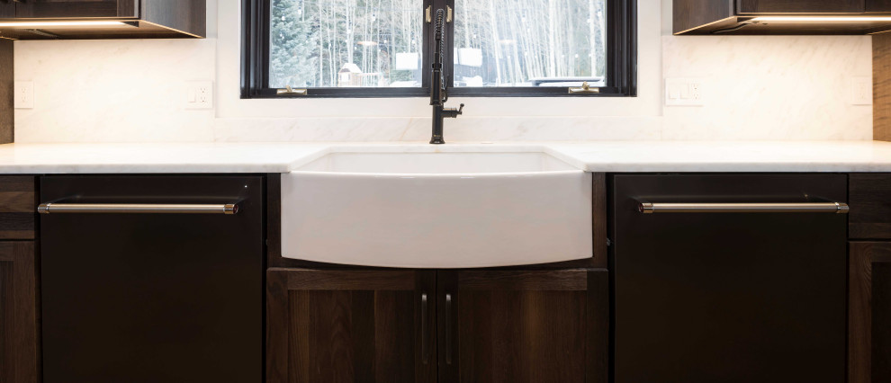 Open concept kitchen - huge transitional single-wall dark wood floor, brown floor and shiplap ceiling open concept kitchen idea in Denver with a farmhouse sink, shaker cabinets, dark wood cabinets, marble countertops, paneled appliances, an island and white countertops