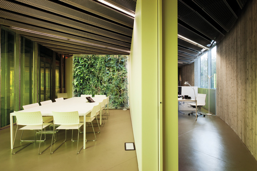 Geräumiges Modernes Arbeitszimmer mit Arbeitsplatz, bunten Wänden, Betonboden, freistehendem Schreibtisch, braunem Boden, eingelassener Decke und vertäfelten Wänden in Mailand
