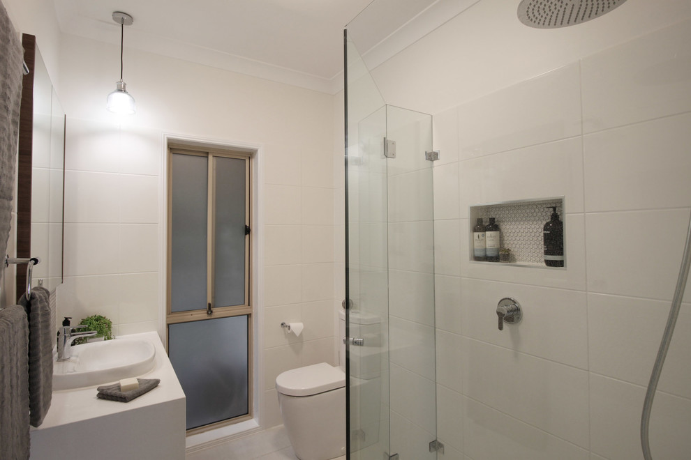 Inspiration for a small contemporary master bathroom in Brisbane with flat-panel cabinets, dark wood cabinets, an alcove shower, a two-piece toilet, white tile, ceramic tile, white walls, porcelain floors, a drop-in sink, engineered quartz benchtops, beige floor, a hinged shower door and white benchtops.