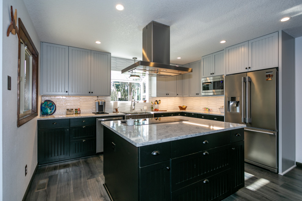Inspiration for a mid-sized transitional kitchen in Portland with a farmhouse sink, black cabinets, quartzite benchtops, white splashback, porcelain splashback, stainless steel appliances, laminate floors, with island, grey floor, multi-coloured benchtop and recessed-panel cabinets.