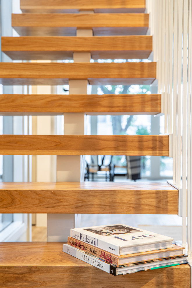 Photo of a mid-sized modern wood floating staircase in Dallas with metal risers and metal railing.