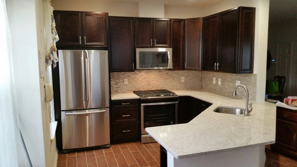 Inspiration for a mid-sized transitional l-shaped laminate floor and brown floor enclosed kitchen remodel in DC Metro with an undermount sink, recessed-panel cabinets, dark wood cabinets, quartzite countertops, white backsplash, mosaic tile backsplash, stainless steel appliances, a peninsula and white countertops