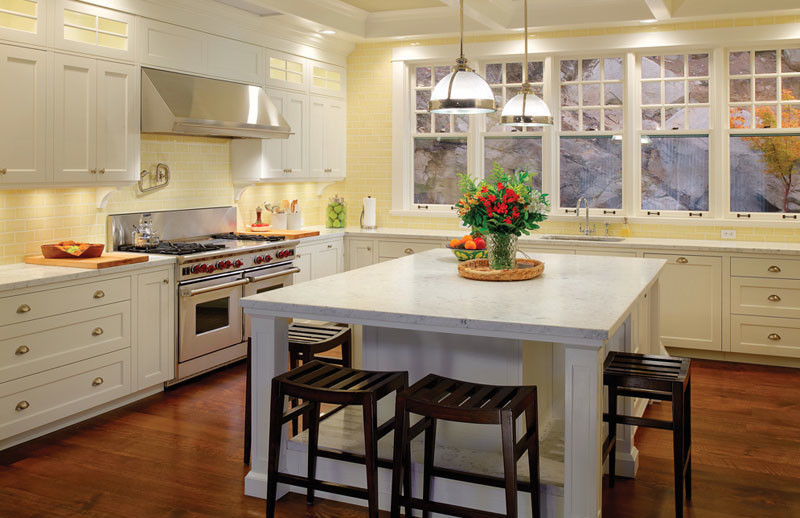 Inspiration for a large transitional u-shaped medium tone wood floor eat-in kitchen remodel in Vancouver with an undermount sink, recessed-panel cabinets, white cabinets, marble countertops, yellow backsplash, subway tile backsplash, stainless steel appliances and an island