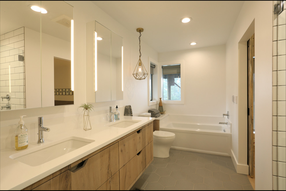 Design ideas for a large transitional master bathroom in Portland with flat-panel cabinets, medium wood cabinets, an alcove tub, an alcove shower, a one-piece toilet, white tile, subway tile, white walls, porcelain floors, an undermount sink, engineered quartz benchtops, brown floor and a hinged shower door.