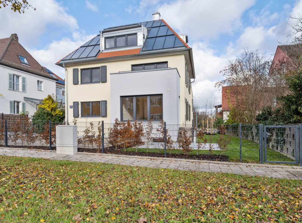 ミュンヘンにある高級なおしゃれな家の外観 (漆喰サイディング、黄色い外壁、アパート・マンション) の写真