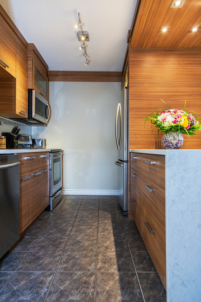 Photo of a small transitional galley eat-in kitchen in Montreal with an undermount sink, flat-panel cabinets, light wood cabinets, metallic splashback, metal splashback, stainless steel appliances, ceramic floors, a peninsula and quartzite benchtops.