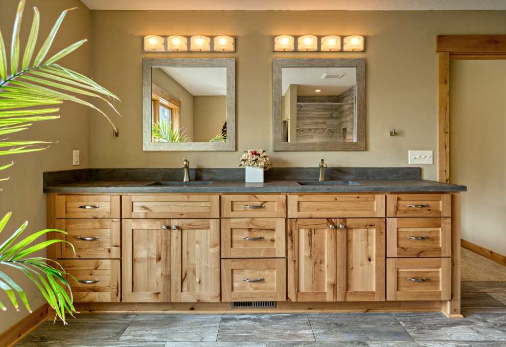 Photo of a large arts and crafts master bathroom in Minneapolis with shaker cabinets, light wood cabinets, a drop-in tub, an alcove shower, a two-piece toilet, multi-coloured tile, porcelain tile, beige walls, porcelain floors, an undermount sink, concrete benchtops, multi-coloured floor, a hinged shower door, grey benchtops, a shower seat, a double vanity and a built-in vanity.