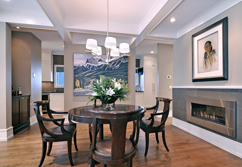 Design ideas for a transitional dining room in Calgary with grey walls, dark hardwood floors, a ribbon fireplace and a metal fireplace surround.