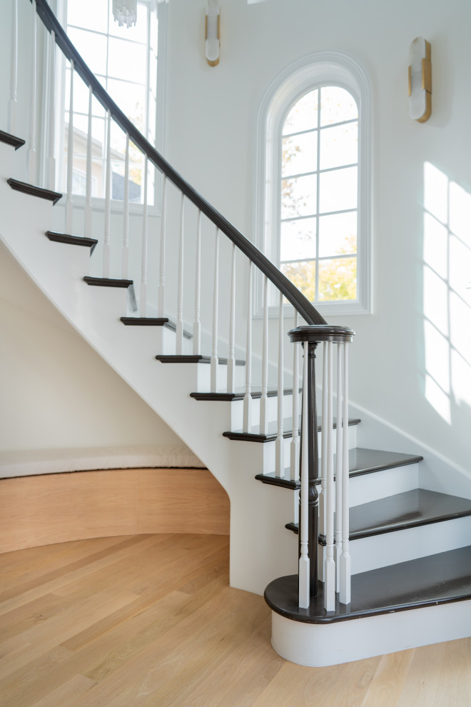 Elegant Home Interior Entrance With Curved Staircase and Black Double Doors