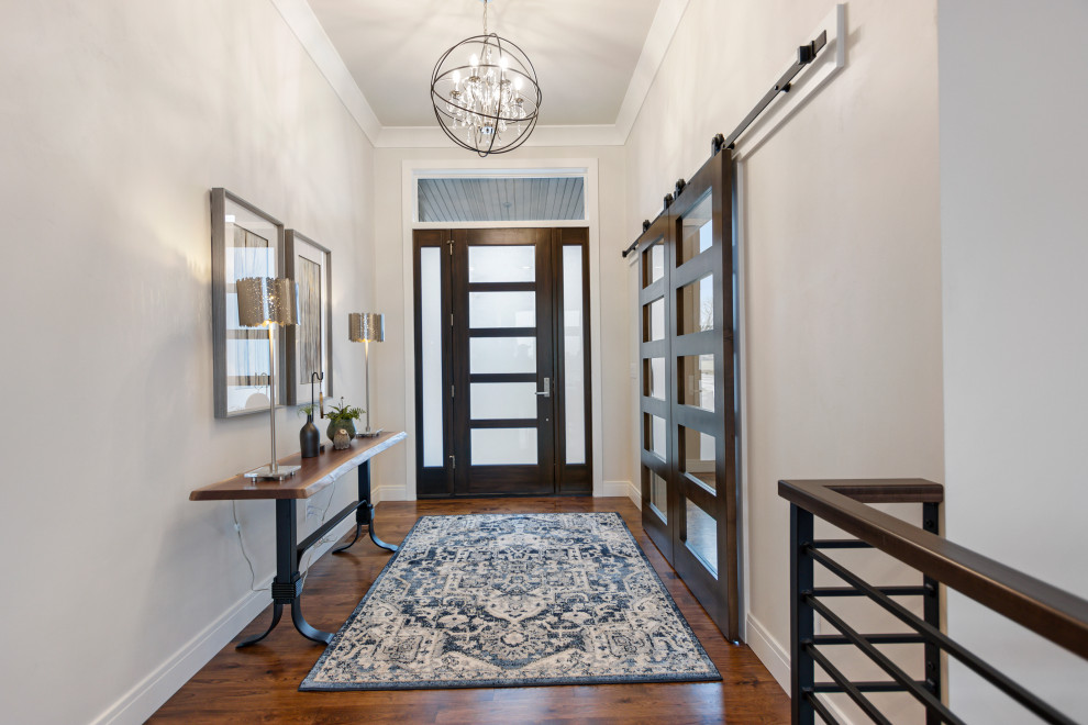 Foyer - mid-sized transitional medium tone wood floor and brown floor foyer idea with white walls and a brown front door