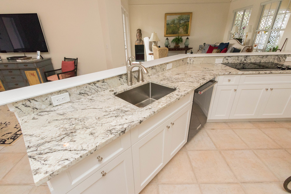 Inspiration for a large transitional porcelain tile eat-in kitchen remodel in Miami with an undermount sink, shaker cabinets, white cabinets, granite countertops, gray backsplash, stone slab backsplash, black appliances and an island