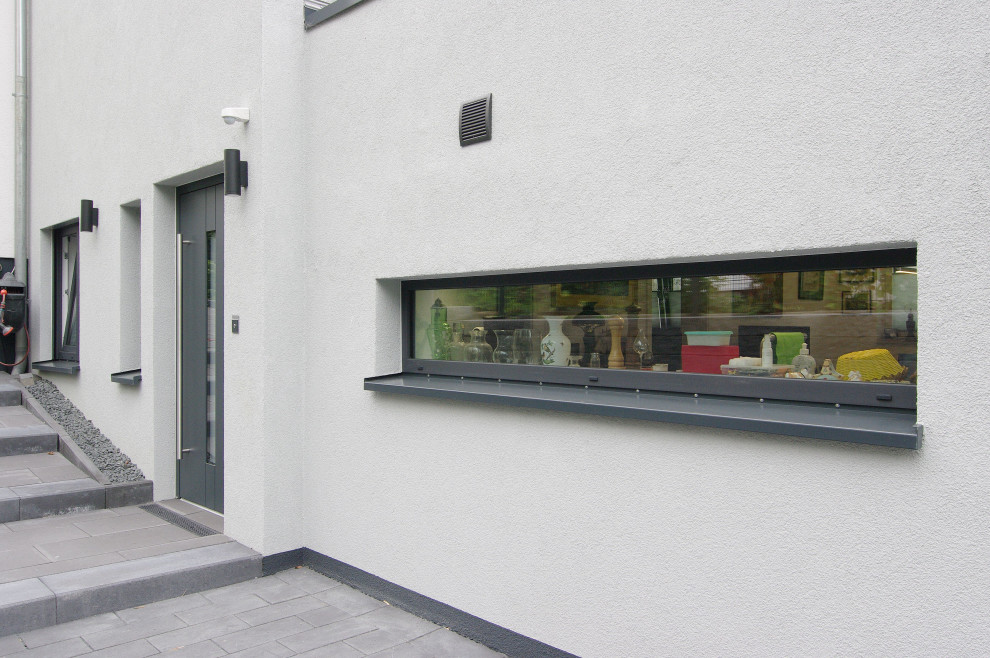 Geräumige Moderne Haustür mit weißer Wandfarbe, Einzeltür, Haustür aus Metall, grauem Boden und Treppe in Düsseldorf