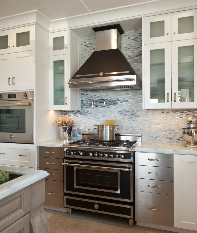 Transitional kitchen in Orange County with mosaic tile splashback, flat-panel cabinets, stainless steel cabinets, quartzite benchtops, blue splashback and black appliances.