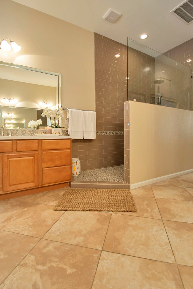 Mid-sized traditional master bathroom in Phoenix with an open shower, brown tile, glass sheet wall, an undermount sink, engineered quartz benchtops, flat-panel cabinets and medium wood cabinets.