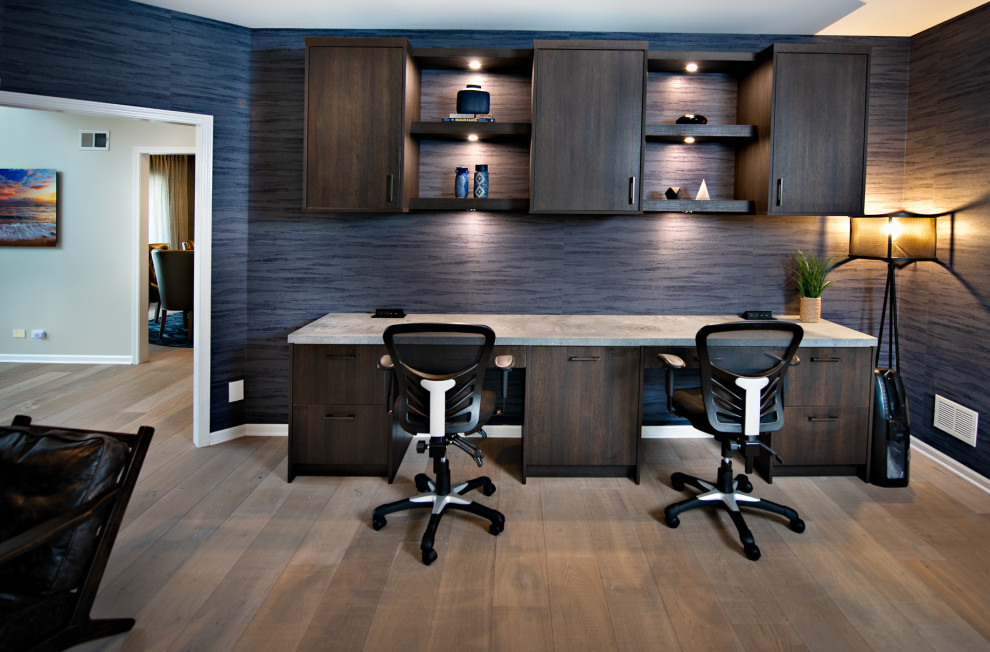 Réalisation d'un grand bureau atelier minimaliste avec un mur bleu, un sol en bois brun, un bureau intégré, un sol marron et du papier peint.