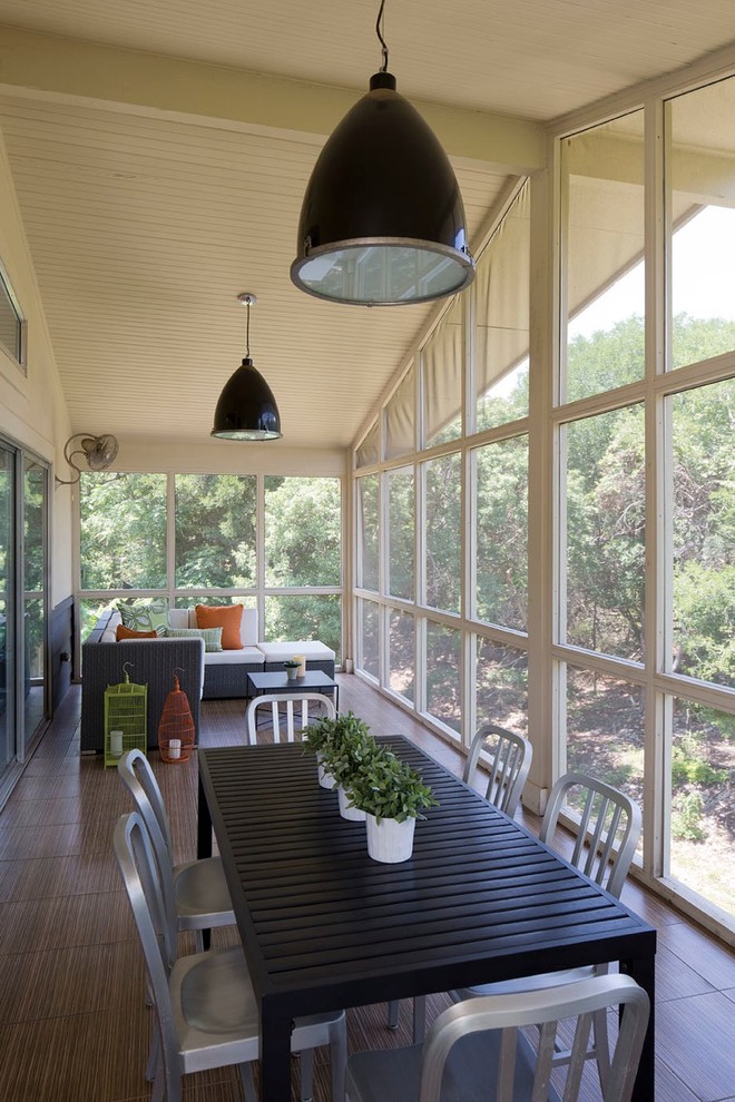 Inspiration for a midcentury side yard screened-in verandah in Austin with tile and a roof extension.