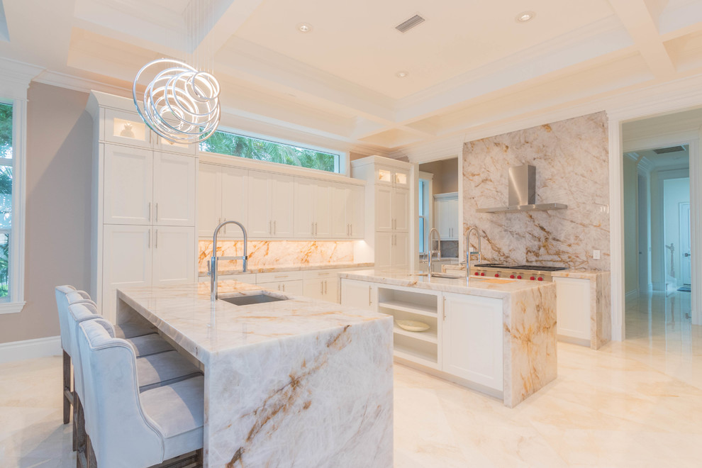 Huge transitional u-shaped marble floor and white floor open concept kitchen photo with an undermount sink, flat-panel cabinets, white cabinets, quartzite countertops, white backsplash, stone slab backsplash and two islands
