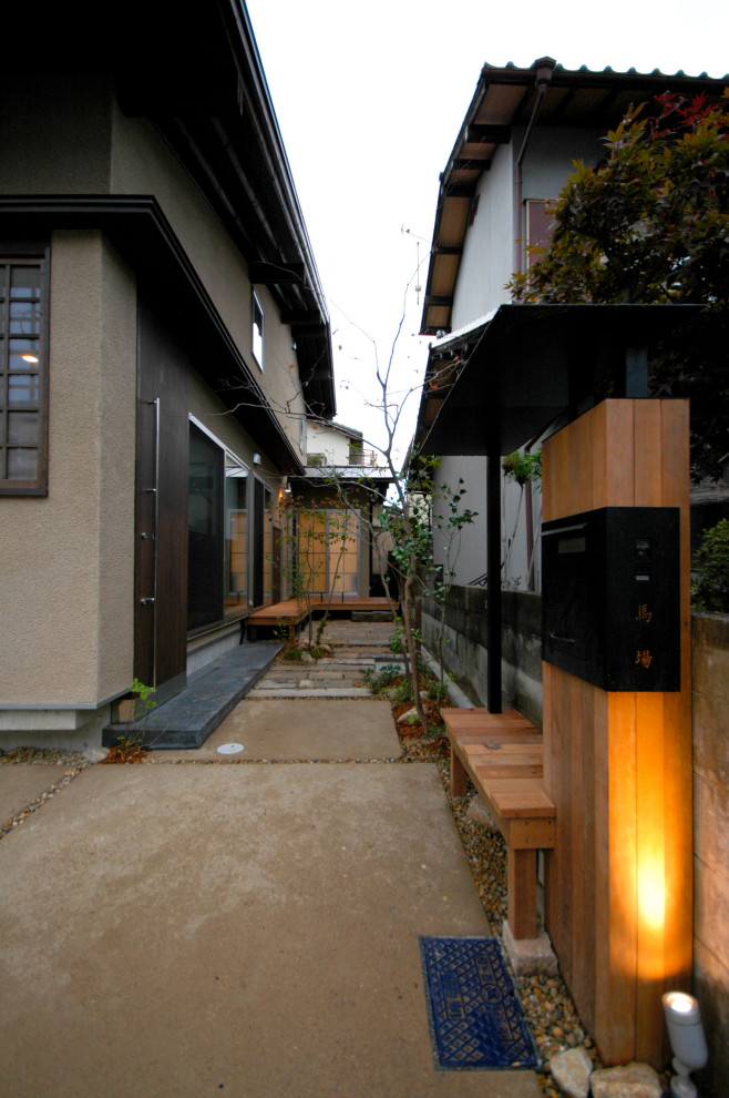 Photo of a small asian front yard full sun driveway in Kyoto with with rock feature and concrete pavers.