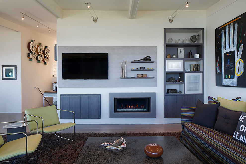 This is an example of a mid-sized contemporary open concept family room in San Francisco with a concrete fireplace surround, white walls, medium hardwood floors, a ribbon fireplace and a built-in media wall.