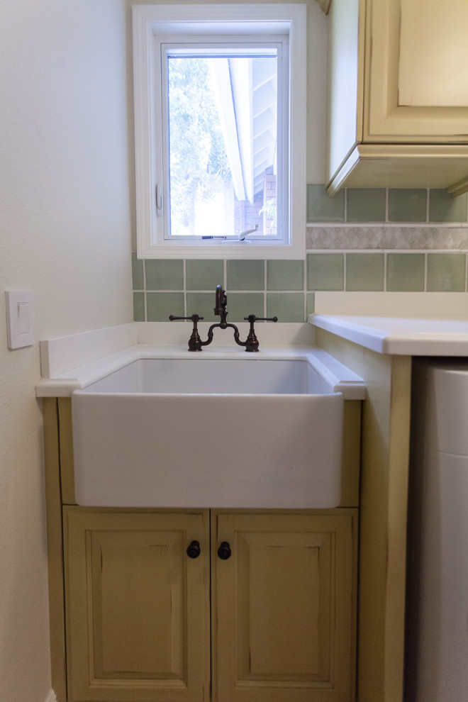 Photo of a mid-sized country single-wall dedicated laundry room in Orange County with a farmhouse sink, raised-panel cabinets, beige cabinets, laminate benchtops, white walls, ceramic floors and a side-by-side washer and dryer.