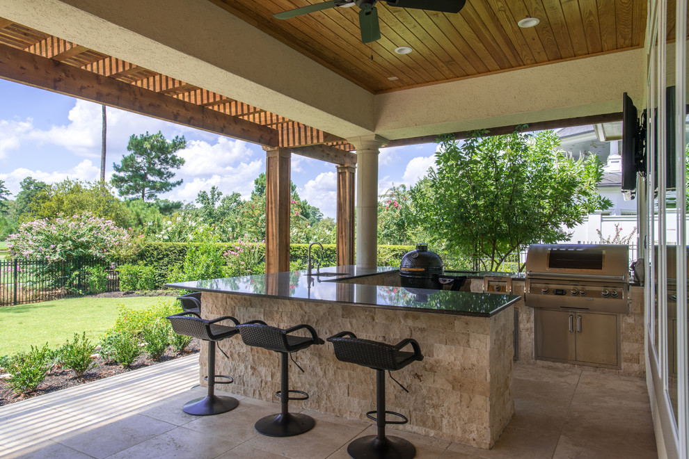 Mid-sized transitional backyard patio in Houston with an outdoor kitchen, tile and a roof extension.