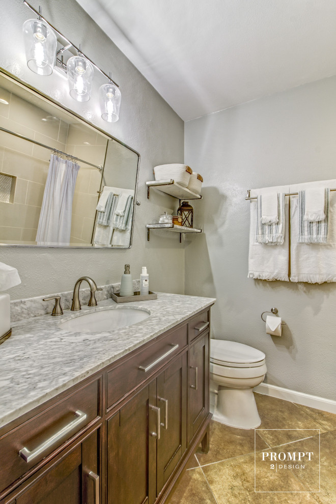 Small transitional bathroom in Austin with recessed-panel cabinets, medium wood cabinets, an alcove tub, a shower/bathtub combo, a one-piece toilet, porcelain tile, green walls, ceramic floors, an undermount sink, marble benchtops, brown floor, a shower curtain, grey benchtops, a single vanity and a freestanding vanity.