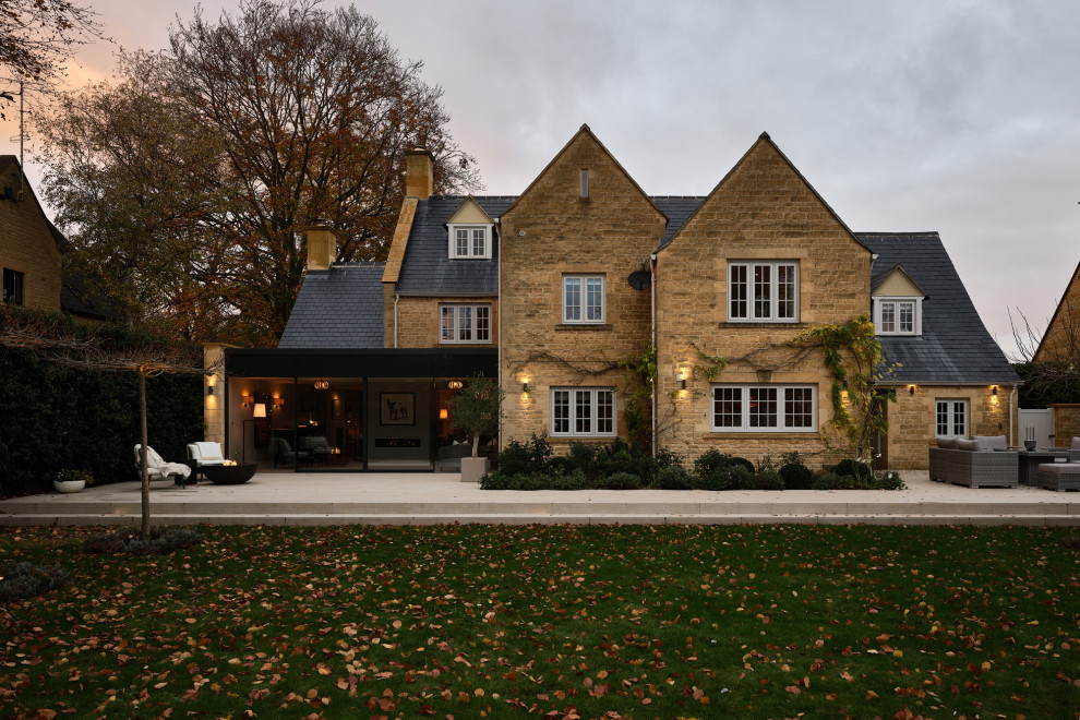На фото: трехэтажный частный загородный дом среднего размера в классическом стиле с облицовкой из камня, двускатной крышей, черепичной крышей и синей крышей с