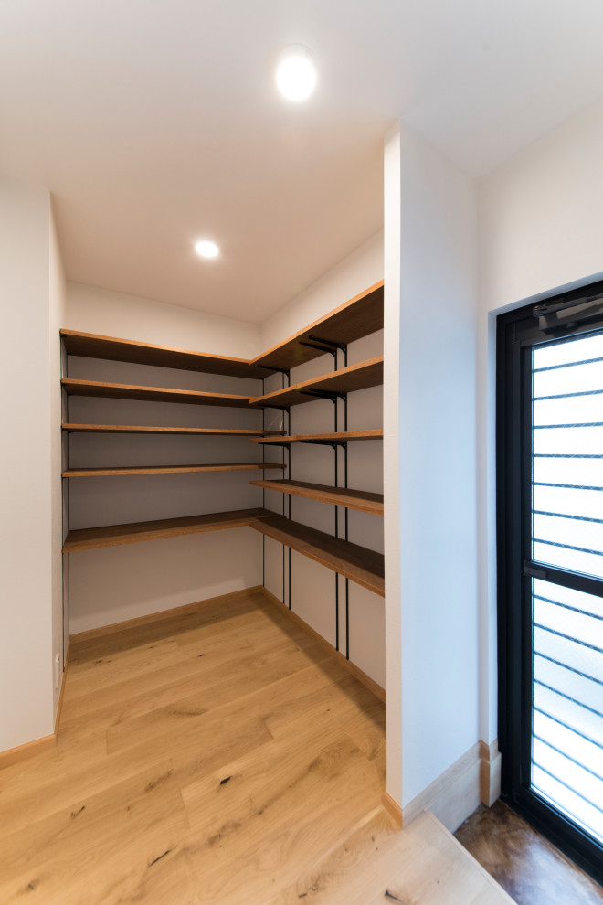 This is an example of a country walk-in wardrobe in Other with dark hardwood floors and beige floor.