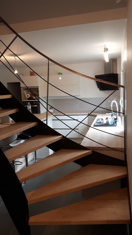 Design ideas for a contemporary wood l-shaped staircase in Lyon with open risers.
