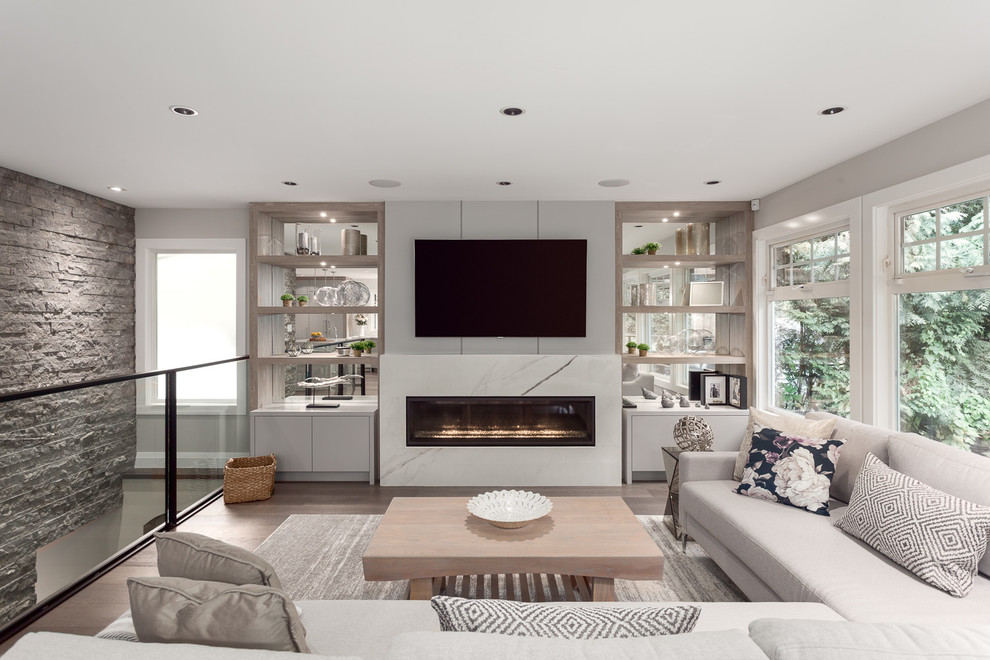 Large contemporary open concept living room in Vancouver with grey walls, a ribbon fireplace, a wall-mounted tv, brown floor, dark hardwood floors and a tile fireplace surround.