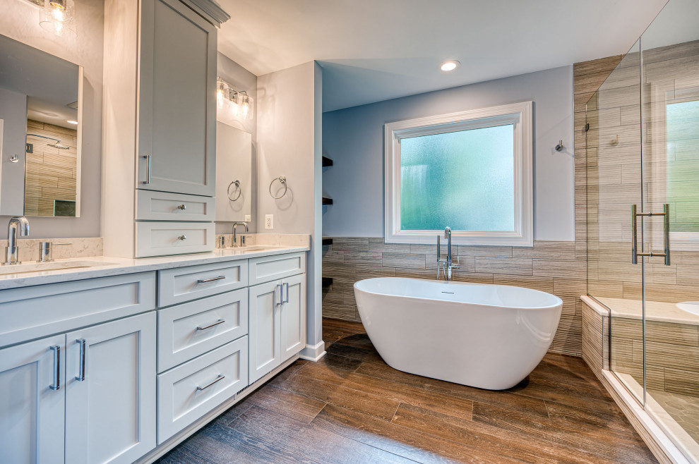 Immagine di una stanza da bagno tradizionale di medie dimensioni con pareti grigie, parquet scuro, top in quarzo composito, due lavabi e mobile bagno incassato
