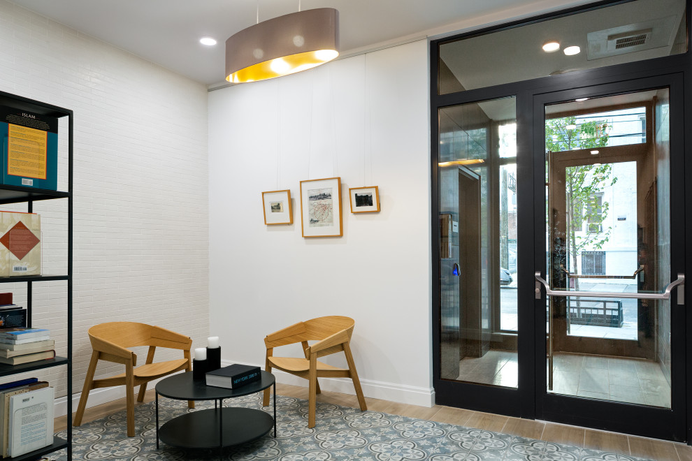 Contemporary foyer in New York with white walls, porcelain floors, a single front door, beige floor and brick walls.