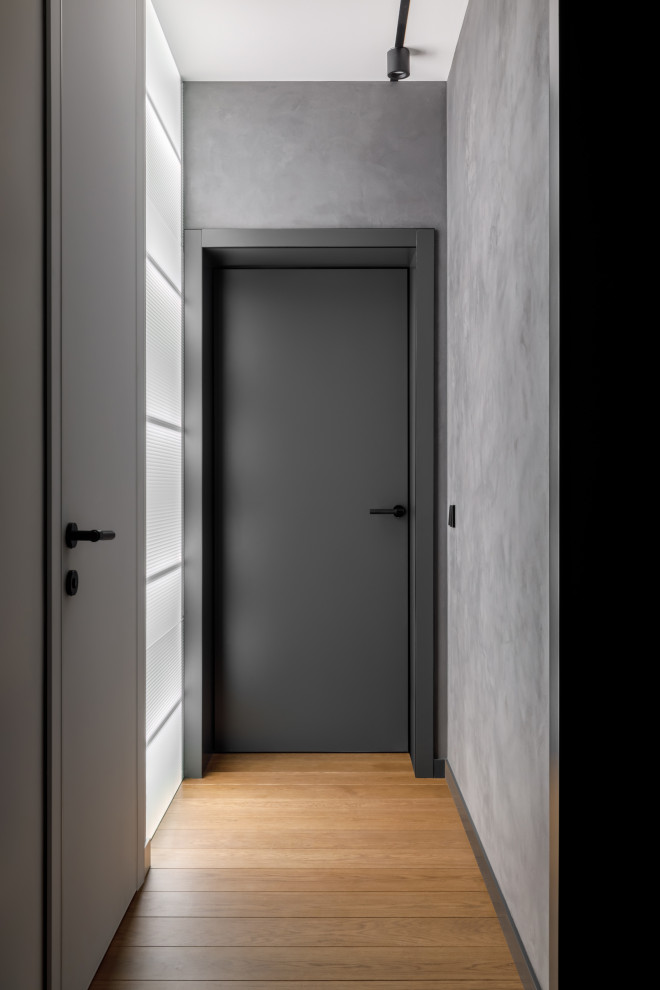 Свежая идея для дизайна: узкий коридор среднего размера в современном стиле с серыми стенами, паркетным полом среднего тона, коричневым полом и панелями на стенах - отличное фото интерьера