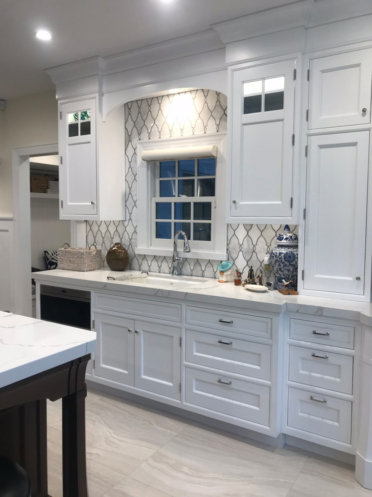 Foto på ett stort vintage flerfärgad kök, med en undermonterad diskho, luckor med infälld panel, vita skåp, bänkskiva i kvarts, flerfärgad stänkskydd, stänkskydd i marmor, integrerade vitvaror, marmorgolv, en köksö och vitt golv