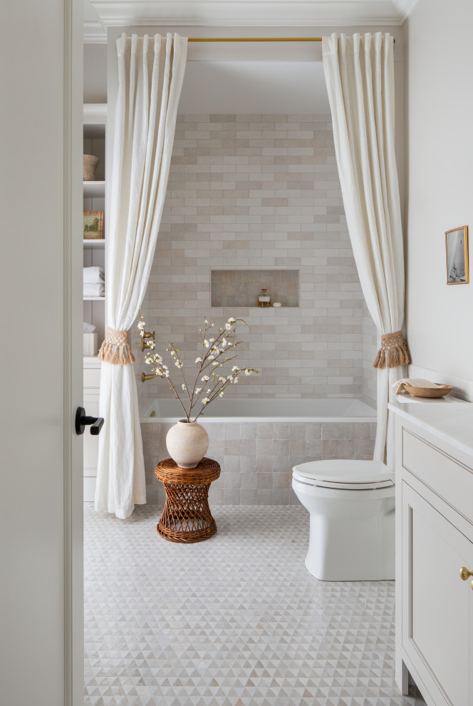 Photo of a classic bathroom in Other with recessed-panel cabinets, beige cabinets, an alcove bath, a shower/bath combination, beige tiles, metro tiles, grey walls, mosaic tile flooring, a shower curtain, white worktops, a wall niche and a built in vanity unit.