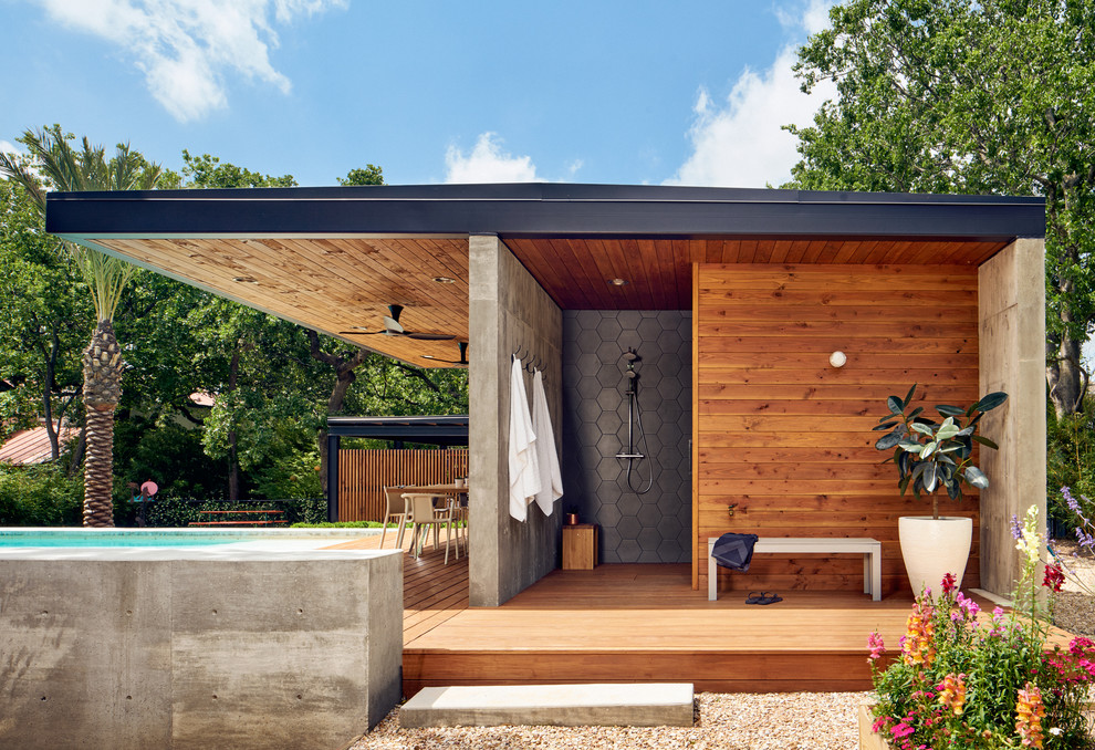 Inspiration for a mid-sized contemporary deck in Austin with an outdoor shower and a roof extension.